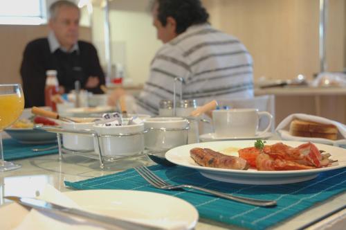 a table with a plate of food on a table at Santorini Guesthouse in East London