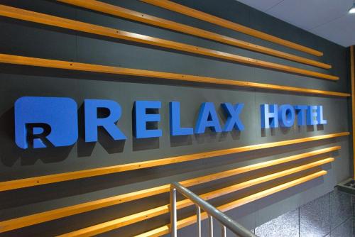 a sign for a riegelax hotel on a wall at Relax Hotel Takayama Station in Takayama