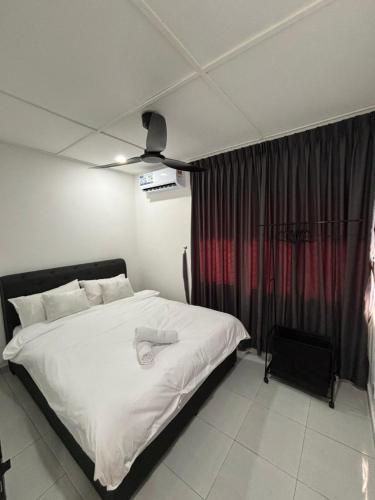 a bedroom with a bed with white sheets and a window at KH Homestay in Kampong Batu Lapan