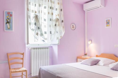 a bedroom with a bed and a chair and a window at Guesthouse Villa Marija in Motovun