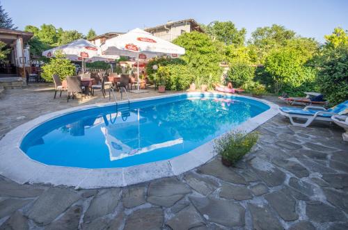 a swimming pool with blue water in a yard at Guest House La Casa in Varna City