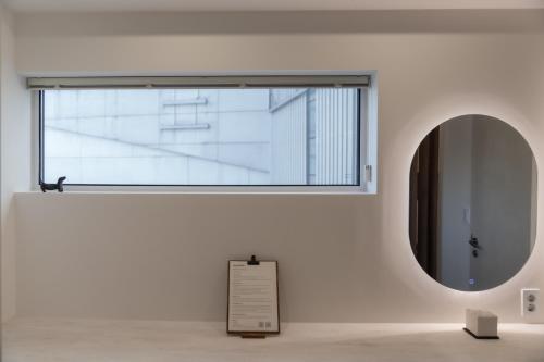 a large window in a white wall with a mirror at StayShim in Seoul