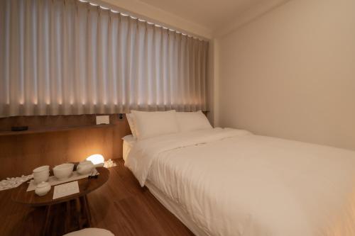 a bedroom with a large white bed and a table at StayShim in Seoul
