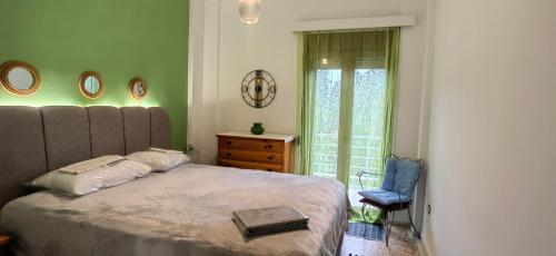a bedroom with a large bed and a chair at AVRA House in Karfas