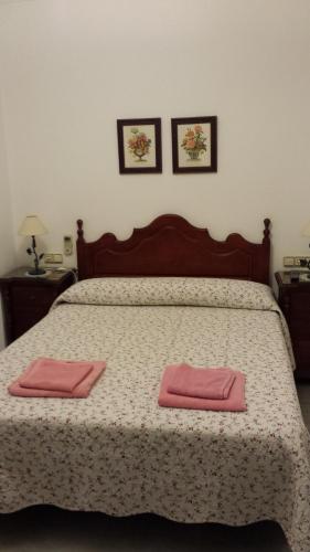 a bedroom with a bed with two pink towels on it at Apartamento San Benito "B" in Seville