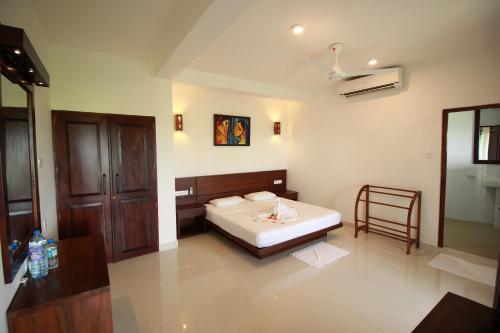 a bedroom with a bed and a chair in it at Hideaway Lodge in Tangalle