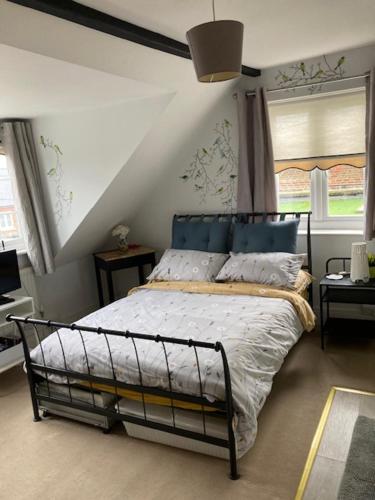 a bedroom with a bed with a blue head board at House on the Corner B&B in Didcot