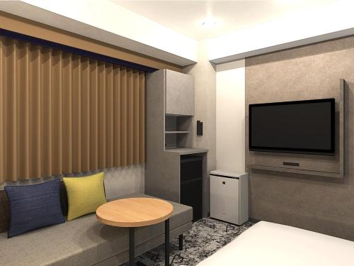 a living room with a tv and a table at Hotel Keihan Kyobashi Grande in Osaka