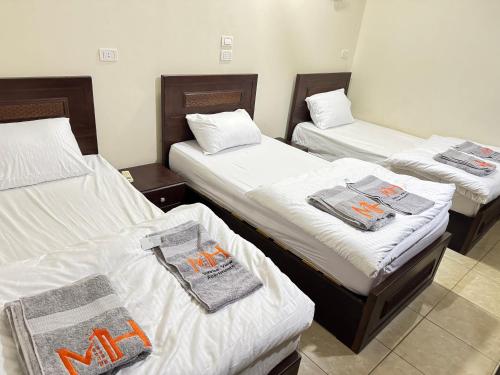 three beds in a room with towels on them at Safaga SeaView Rooftop in Safaga