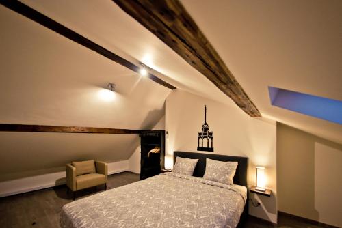 - une chambre avec un lit et une chaise dans l'établissement Les Suites de Nanesse, à Liège