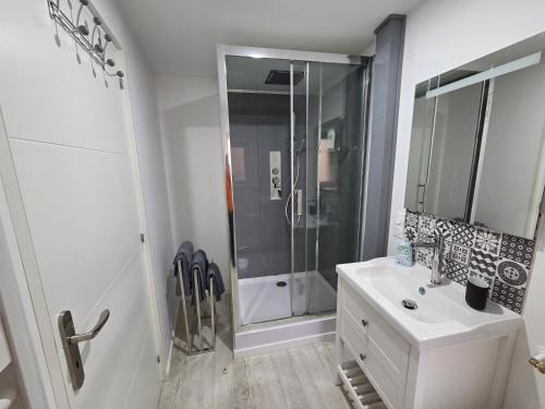 a white bathroom with a shower and a sink at Nuit douce au LYS in Phalsbourg