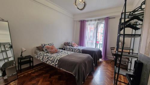 a living room with two beds and a shelf at Mini Hostel in Lisbon in Lisbon