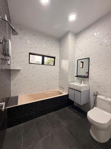 a bathroom with a toilet and a tub and a sink at De'Lunar Homestay in Johor Bahru