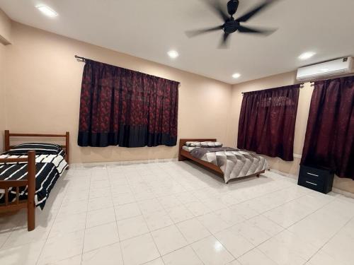 a room with two beds and a ceiling fan at De'Lunar Homestay in Johor Bahru