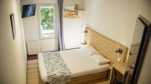 a small bedroom with a bed and a window at my HOTEL Bordeaux in Artigues-près-Bordeaux