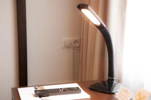 a black lamp sitting on a table with a remote control at Hotel Ochsen in Bad Saulgau
