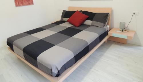 a bed in a room with a red pillow on it at Tom e Jerry in Lierna
