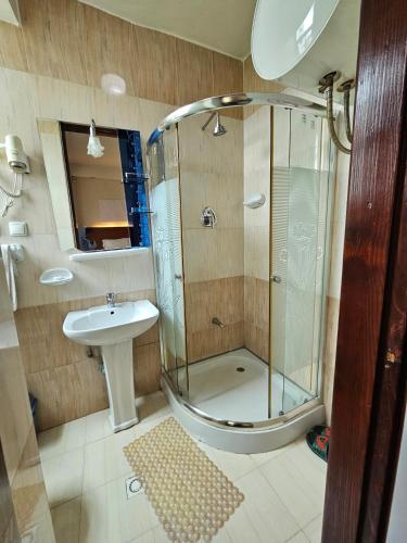 a bathroom with a shower and a sink at C Fun Addis Hotel in Addis Ababa