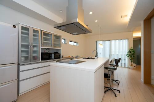 a kitchen with white cabinets and a white counter top at ISE Resort 綾 UZ1 in Ise