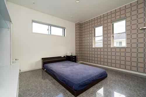 a bedroom with a bed and two windows at ISE Resort 綾 UZ1 in Ise