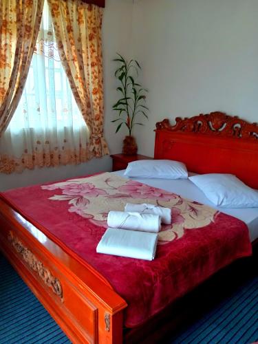 a bedroom with a bed with two towels on it at Ragith Villa in Nuwara Eliya