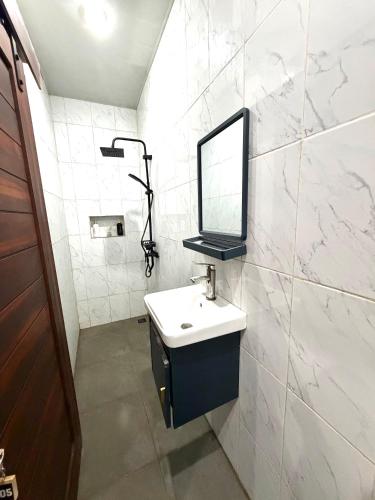 a bathroom with a sink and a mirror on the wall at Lestari Homestay Jimbaran in Jimbaran