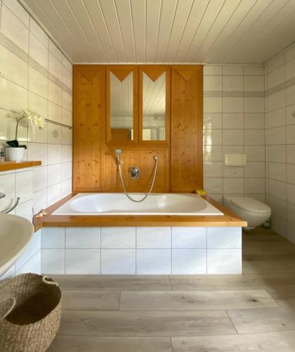 a bathroom with a tub and a toilet and a sink at Auszeit Ferienhaus Nr 2 und 2a in Sierscheid