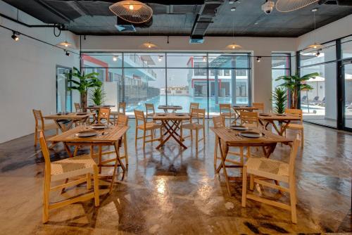 a restaurant with wooden tables and chairs and windows at KAY Homes in Ras al Khaimah