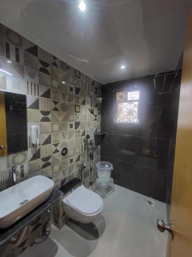 a bathroom with a toilet and a sink at Ammora Resort in Kārli