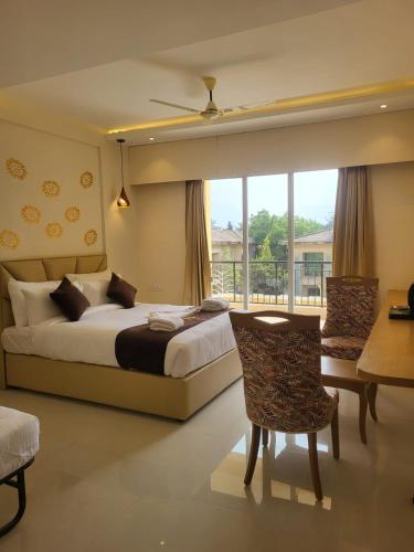 a bedroom with a bed and a desk and a window at Ammora Resort in Kārli