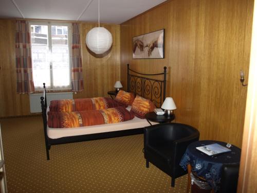 a bedroom with a bed with orange sheets and a window at Hotel Bel-Air Eden in Grindelwald