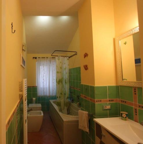 a green and yellow bathroom with a tub and a sink at Princely Houses in Positano