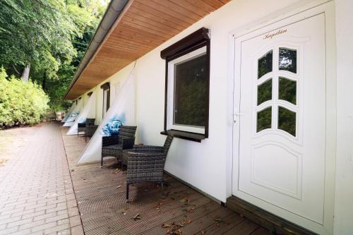 a porch with chairs and a white door at Koserow Hotel Wald und Meer in Koserow