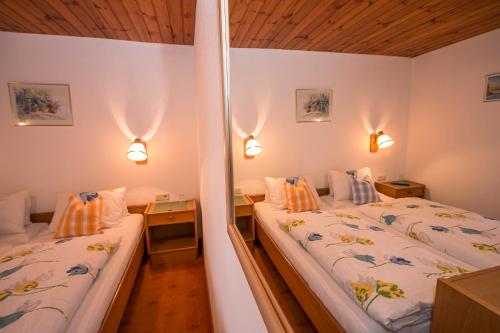 1 dormitorio con 2 camas y 2 luces en la pared en Pension Andrea, en Fusch an der Glocknerstrasse