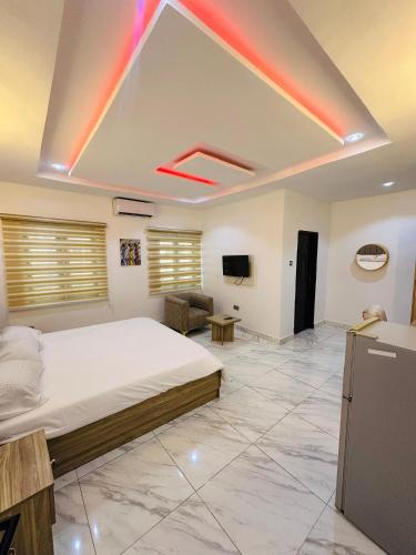 ein großes Schlafzimmer mit Bett und Fernseher in der Unterkunft Stan - Haven Apartments ASOKORO in Asokoro