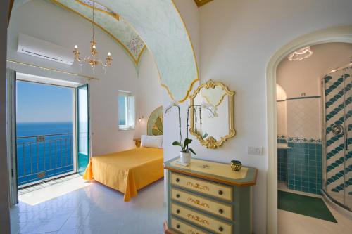 a bedroom with a bed and a bathroom with a window at Palazzo Rocco Villa Sunshining in Love in Praiano