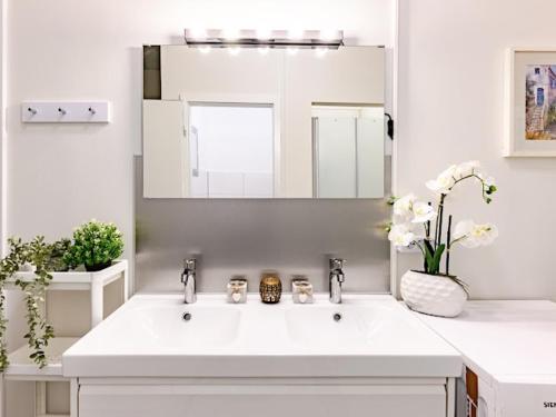 a white bathroom with a sink and a mirror at Attic apartment in villa! in Berlin