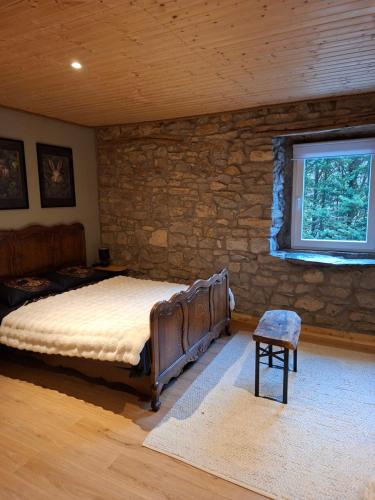 a bedroom with a bed and a stone wall at Au loupus in Durbuy