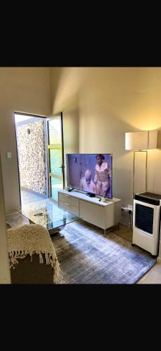 a living room with a large flat screen tv at Mwenda Residence in Ongwediva