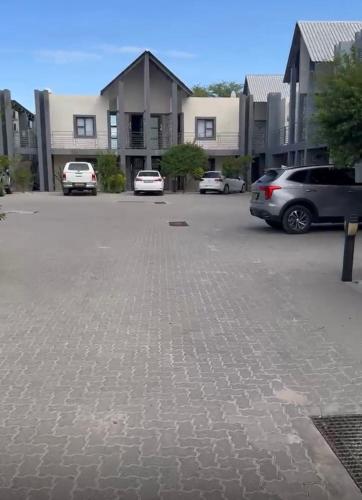 a parking lot with cars parked in front of houses at Mwenda Residence in Ongwediva
