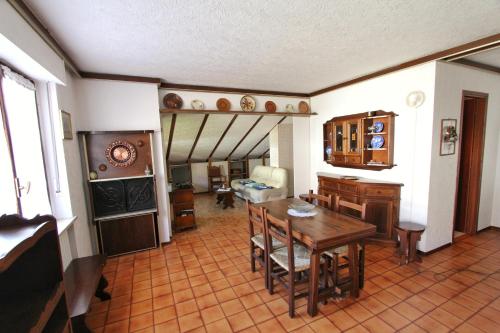 un soggiorno con tavolo e una sala da pranzo di Hostdomus - Bi Level Apartment a Pragelato