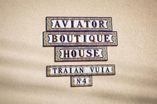 three street signs on the wall of a house at Hotel Aviator Boutique in Otopeni