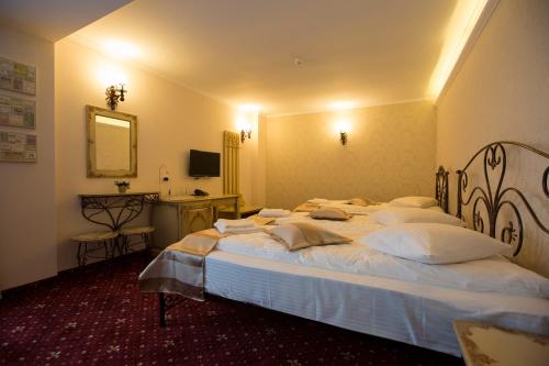 a bedroom with a large bed with white pillows at Hotel Aviator Boutique in Otopeni