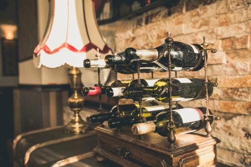 a bunch of wine bottles on a table next to a lamp at Hotel Aviator Boutique in Otopeni