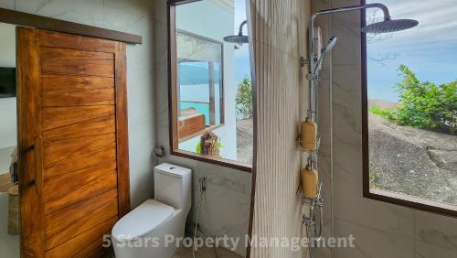 a bathroom with a toilet and a window and a shower at Epic Views Cabins - Ocean or Mountains, your choice in Ko Phangan