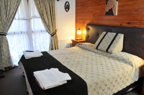 a bedroom with a bed with two towels on it at Apart Cascadas in San Martín de los Andes