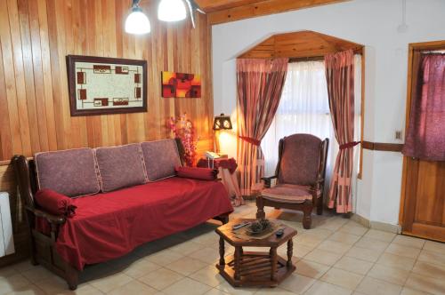 sala de estar con sofá y silla en Apart Cascadas en San Martín de los Andes