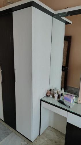 a room with a white cabinet and a table at Gem Backpackers hostel in Siliguri