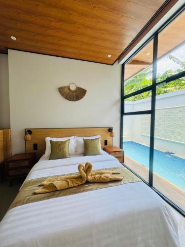 a bedroom with a large bed with a large window at Griya Becik Lovina - Private Pool Villa near Lovina Dolphin Spot in Lovina