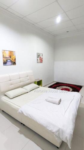a white bedroom with a large white bed at Aaronie Hotel Setiu in Kampong Burok